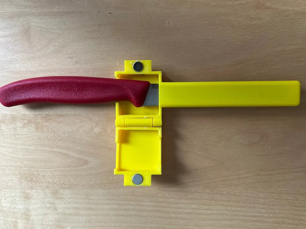 a toy gun with a red handle on a wooden table