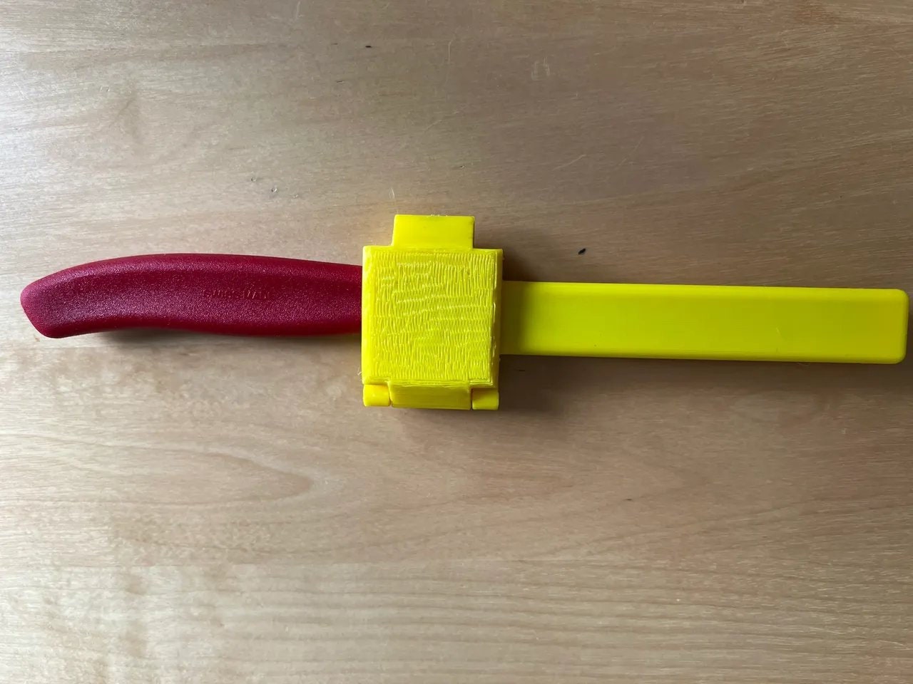a yellow and red object on a wooden surface