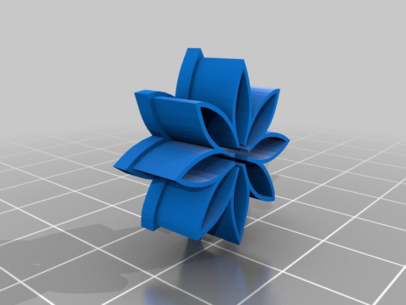 a blue origami flower sitting on top of a tiled floor
