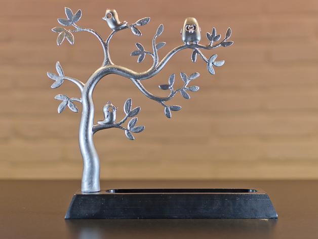 a metal sculpture of a tree with birds on it