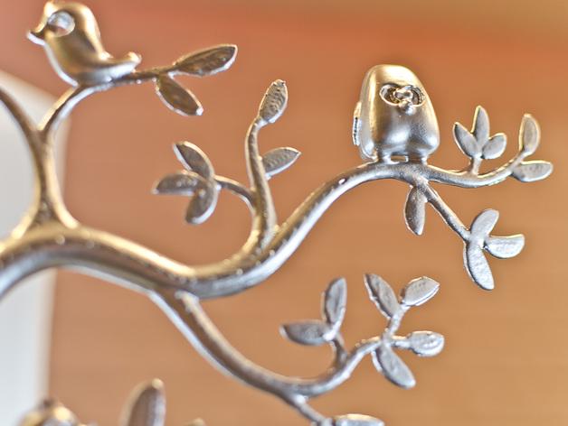 a metal sculpture of a tree with birds on it