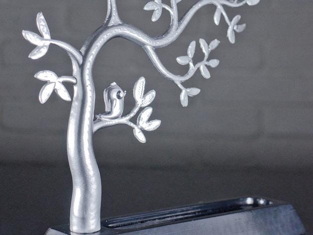 a metal sculpture of a tree with a bird on it