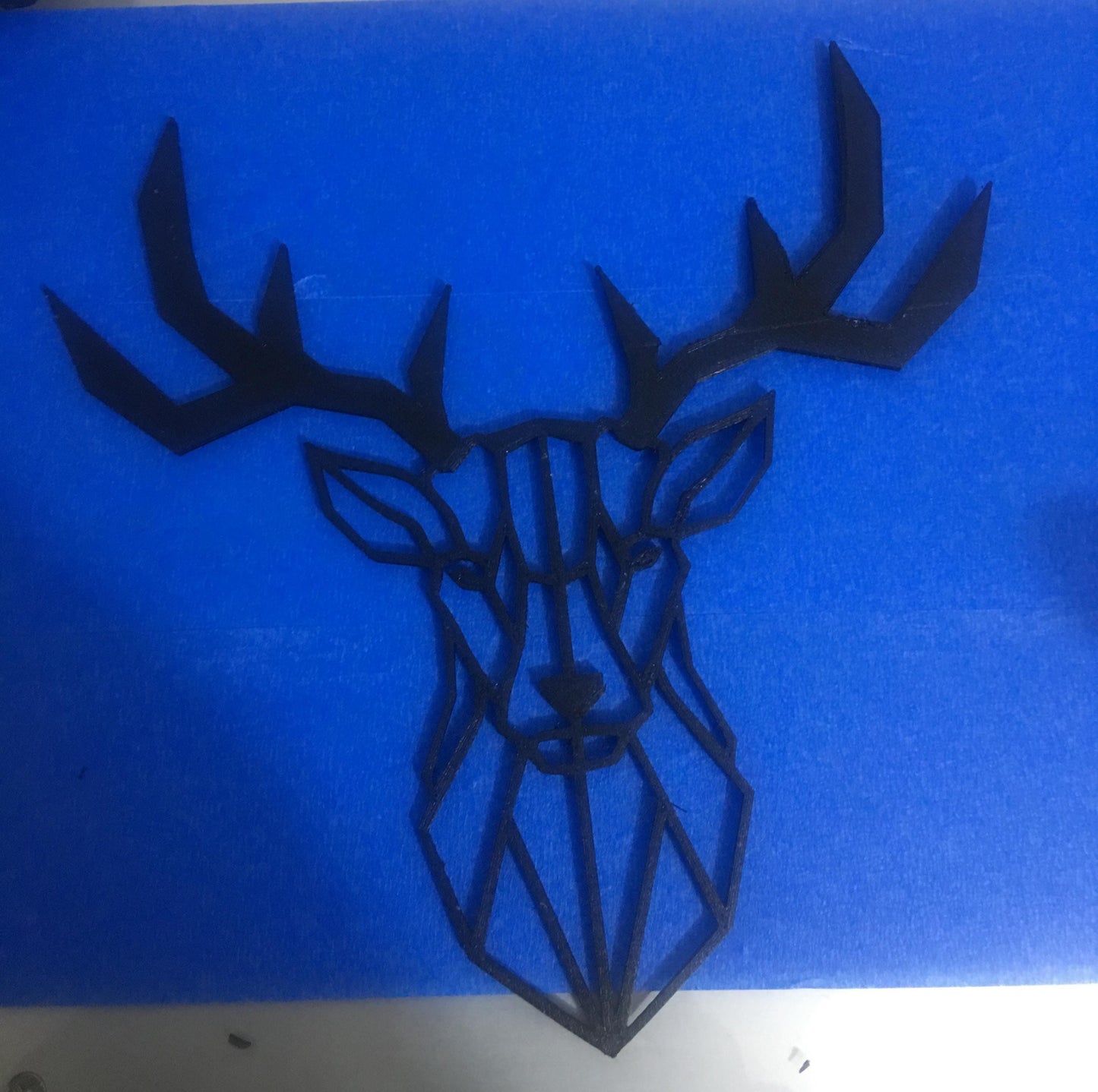 a metal deer head on a blue background