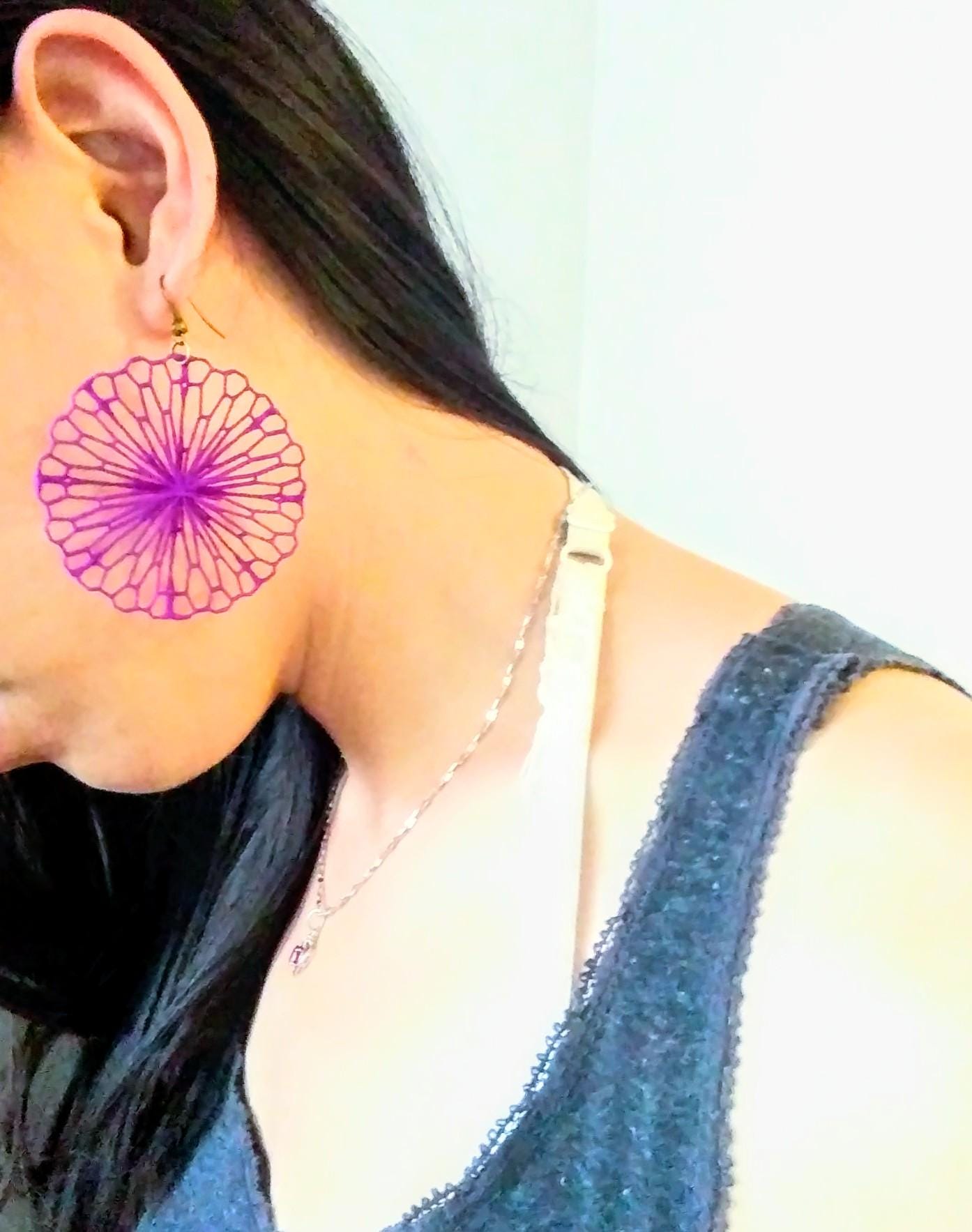 a close up of a person wearing a pair of earrings