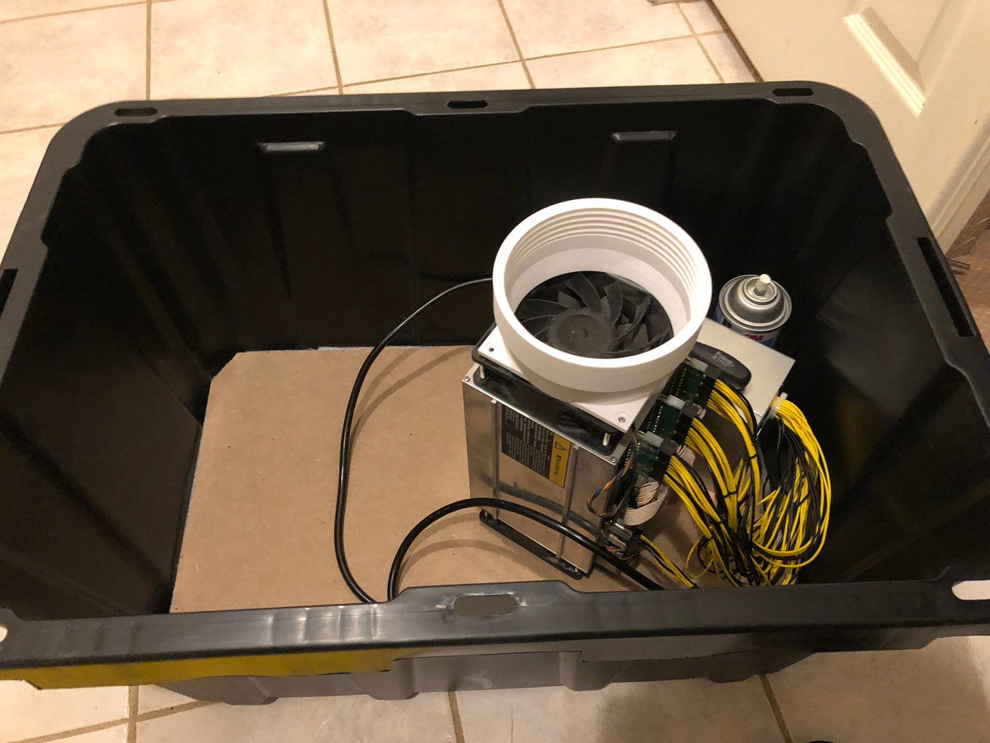 a bucket with a fan and wires inside of it