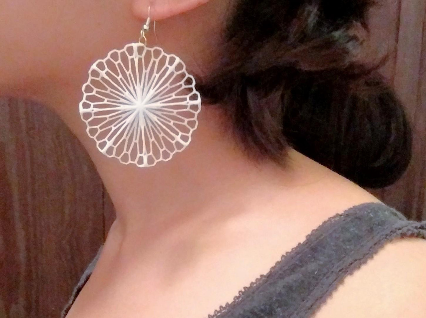 a close up of a person wearing a pair of earrings