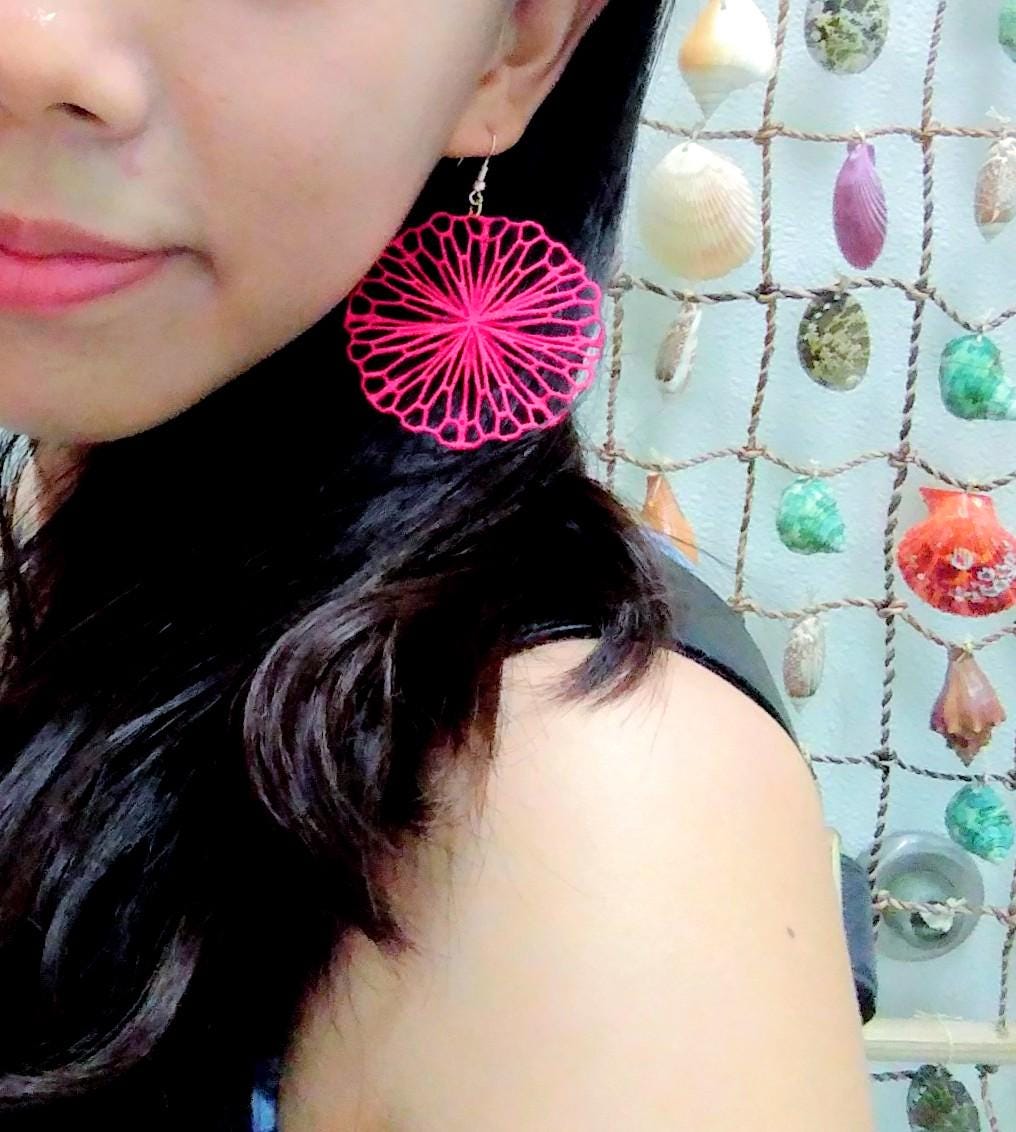 a close up of a person wearing a pair of earrings