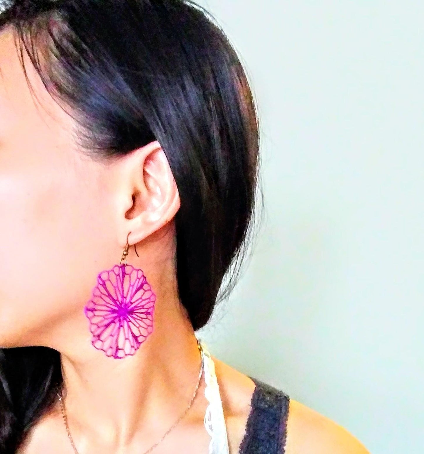 a close up of a person wearing a pair of earrings