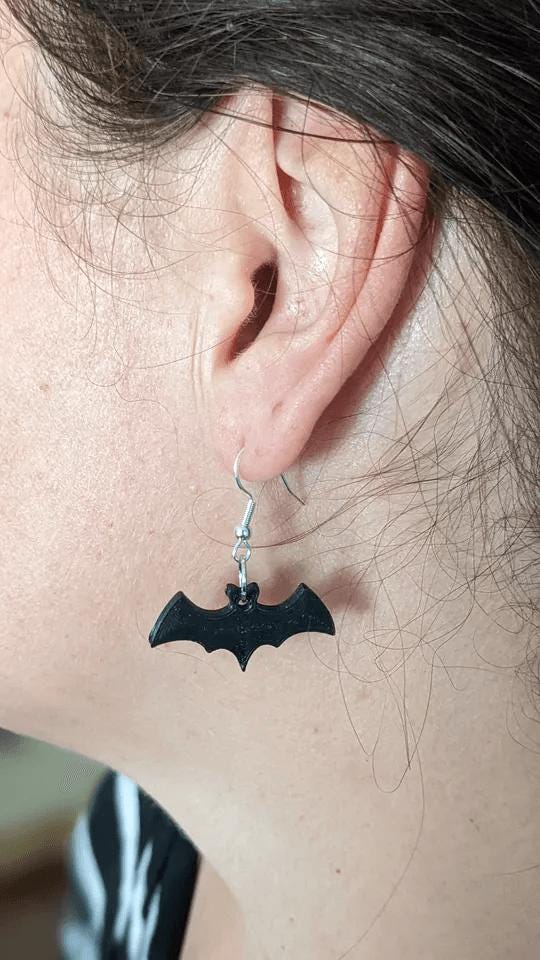 a close up of a person wearing a pair of earrings