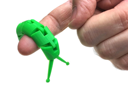 a hand holding a small green object in it&#39;s palm