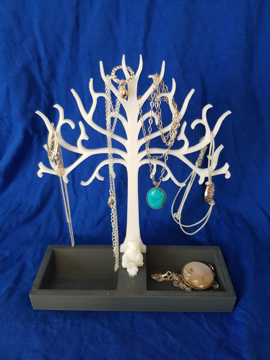 a white tree with jewelry hanging from it&#39;s branches