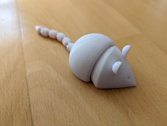 a plastic toy mouse on a wooden floor