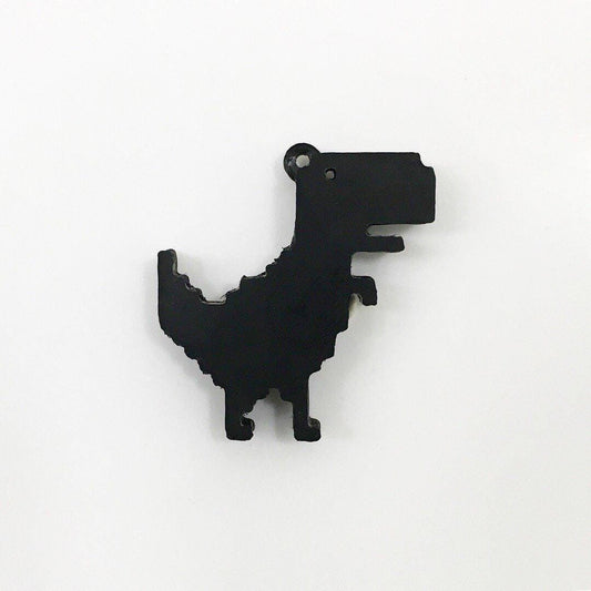 a black dinosaur shaped object on a white surface