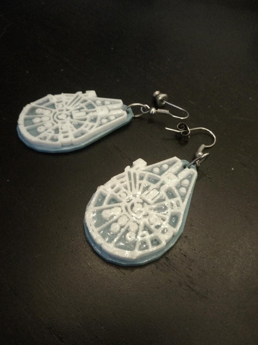 a pair of white earrings sitting on top of a table