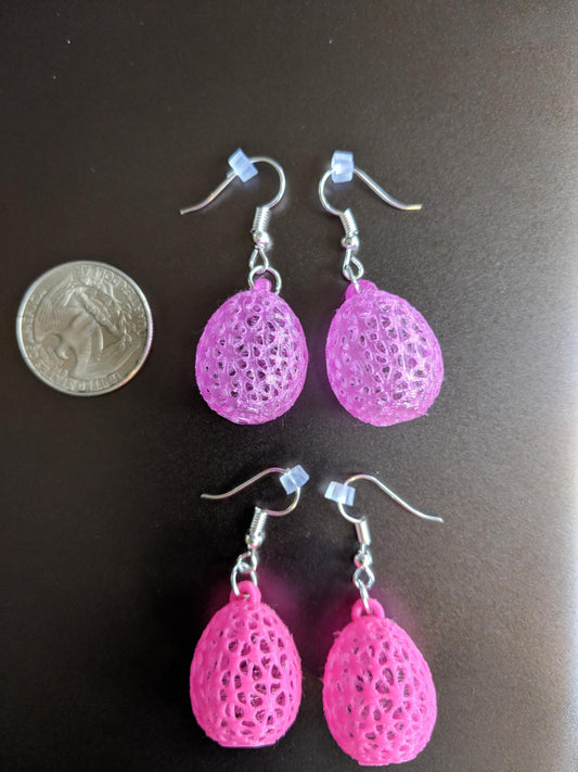 a pair of pink earrings sitting next to a penny