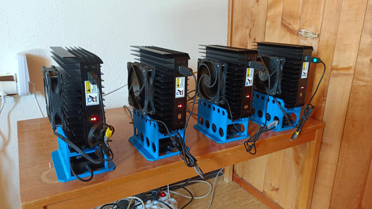 a group of blue and black speakers sitting on top of a wooden table