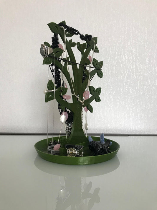 a green tray with a tree made out of jewelry