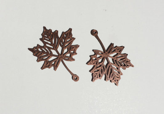 a pair of metal leaves on a white surface