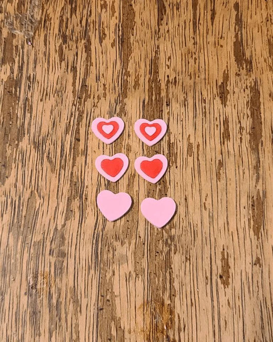 a wooden table topped with pink and red hearts